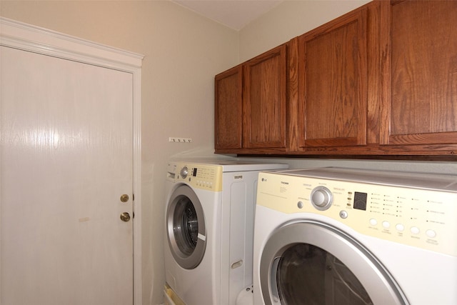 laundry area featuring washing machine and dryer and cabinets