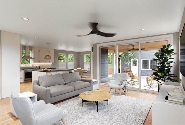 living room with ceiling fan, light hardwood / wood-style flooring, and sink