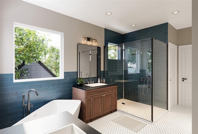 bathroom featuring tile walls, plus walk in shower, tile patterned floors, and vanity