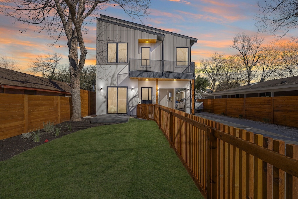 back house at dusk with a yard