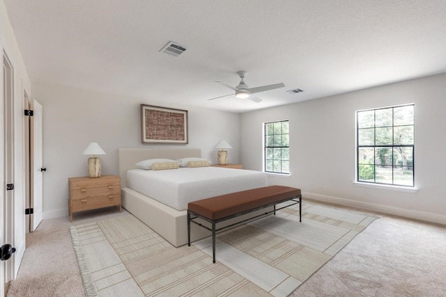 carpeted bedroom with ceiling fan and multiple windows