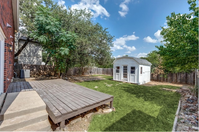 view of yard featuring central AC unit, a storage shed, and a wooden deck