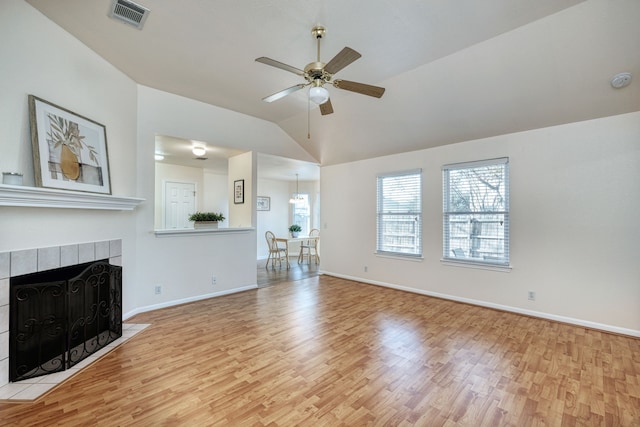 unfurnished living room featuring lofted ceiling, a fireplace, light wood-type flooring, and ceiling fan