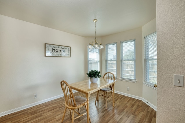 dining area featuring light wood-type flooring and a notable chandelier