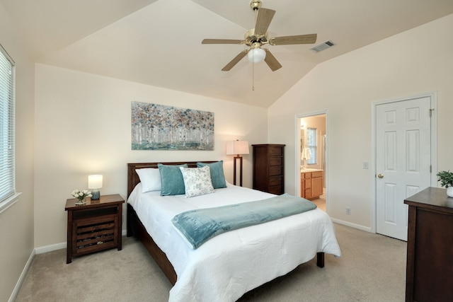 bedroom featuring ceiling fan, light carpet, ensuite bath, and lofted ceiling