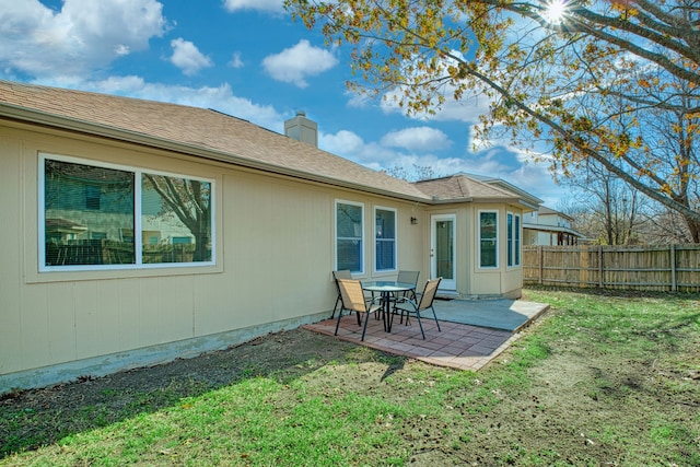 rear view of house with a patio and a yard