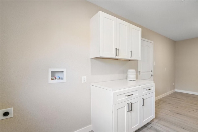 laundry room featuring light hardwood / wood-style flooring, hookup for a washing machine, cabinets, and hookup for an electric dryer