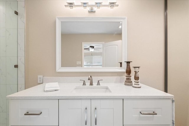 bathroom with ceiling fan, tiled shower, and vanity