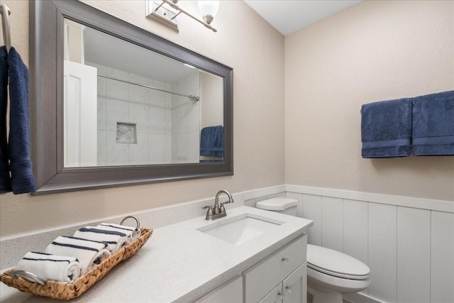 bathroom with toilet, a shower, and vanity