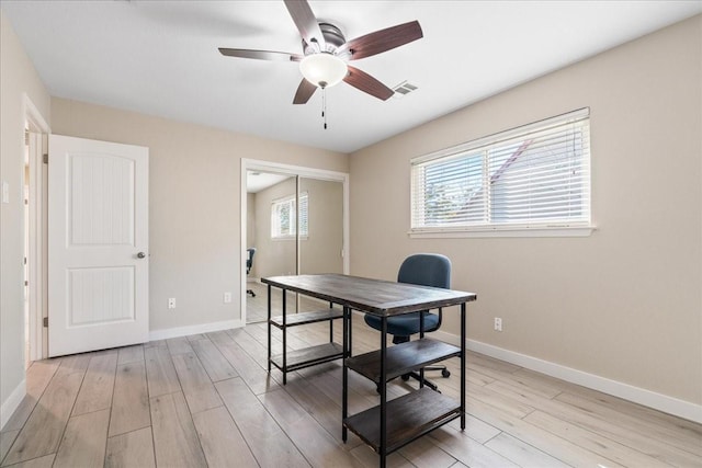 home office with ceiling fan and light hardwood / wood-style floors