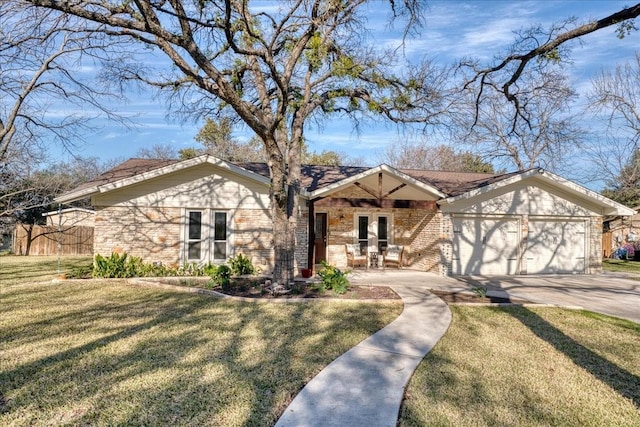 view of front of home with a front yard, a garage, and french doors