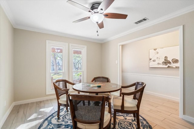 dining space featuring light wood-type flooring, ceiling fan, and ornamental molding