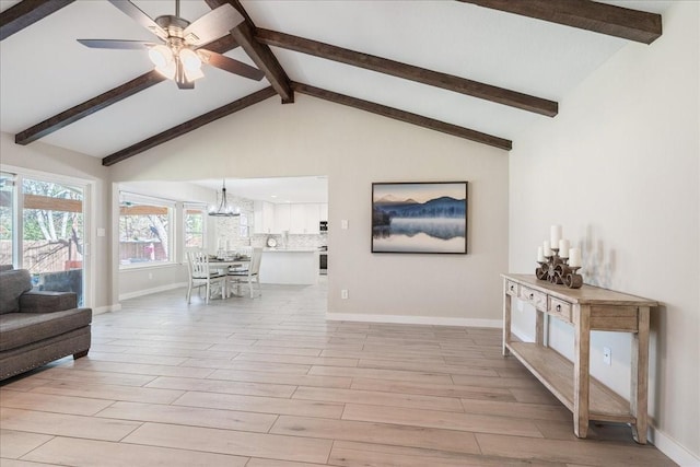 living room featuring light wood-type flooring, lofted ceiling with beams, and ceiling fan with notable chandelier