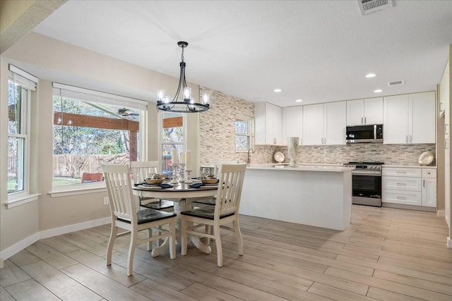 dining area with a notable chandelier and light hardwood / wood-style flooring