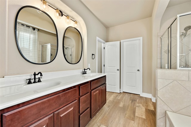 bathroom with a shower with door, vanity, and hardwood / wood-style flooring