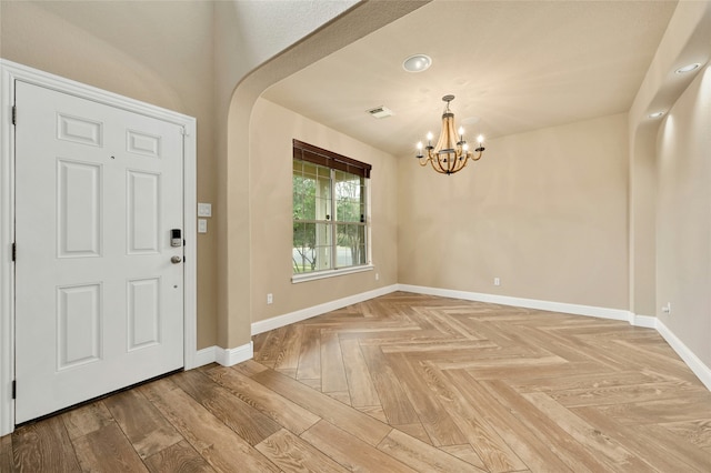 foyer entrance featuring an inviting chandelier and parquet floors