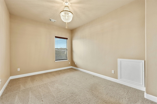 carpeted empty room with a chandelier