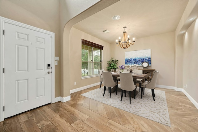 dining room with an inviting chandelier and light parquet flooring