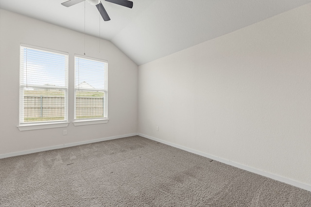 carpeted spare room featuring ceiling fan and vaulted ceiling