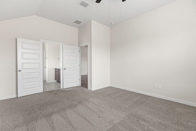 unfurnished bedroom featuring ensuite bathroom, carpet flooring, ceiling fan, and vaulted ceiling