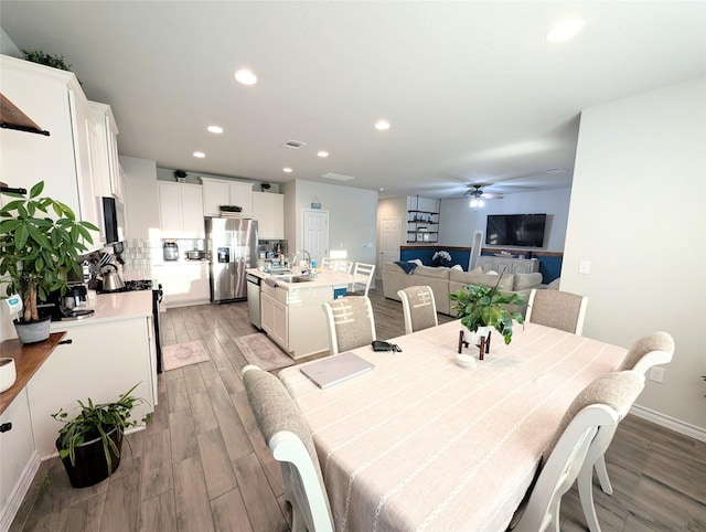 dining room featuring ceiling fan, light hardwood / wood-style flooring, and sink