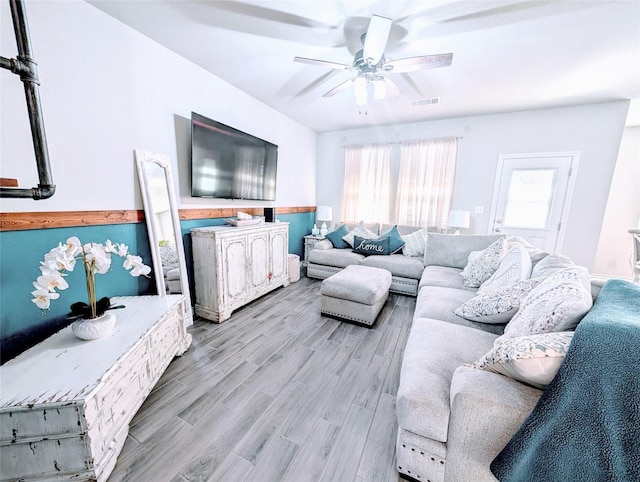 living room with ceiling fan and light hardwood / wood-style flooring