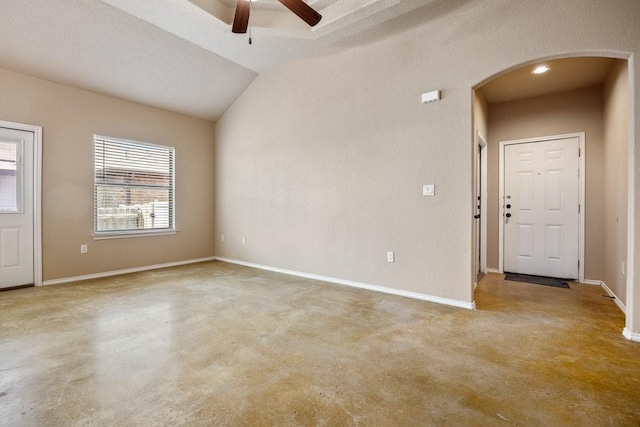 interior space with ceiling fan, lofted ceiling, and concrete flooring