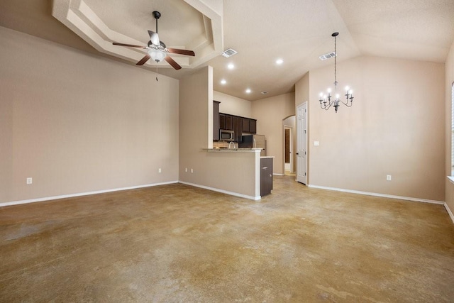 unfurnished living room featuring ceiling fan with notable chandelier and a tray ceiling