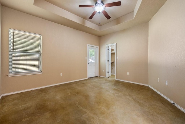 unfurnished room with carpet flooring, ceiling fan, and a tray ceiling