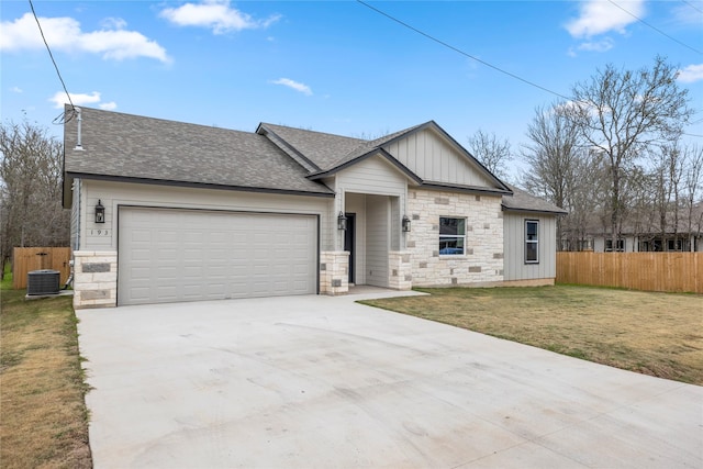 view of front of property with central AC, a front yard, and a garage