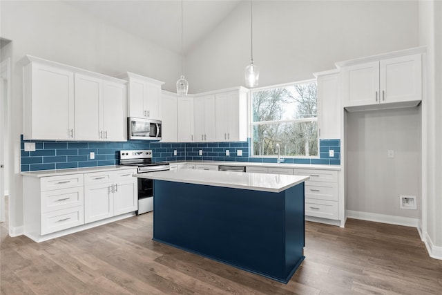 kitchen with a kitchen island, white cabinets, and appliances with stainless steel finishes