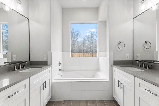 bathroom featuring vanity, tiled bath, and plenty of natural light