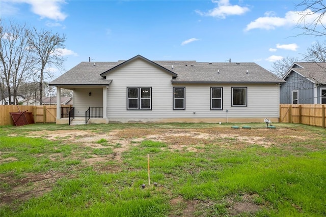 rear view of property featuring a yard