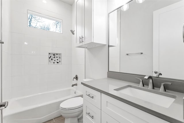 full bathroom with wood-type flooring, toilet, vanity, and tiled shower / bath