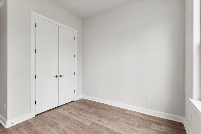 unfurnished bedroom featuring light wood-type flooring and a closet