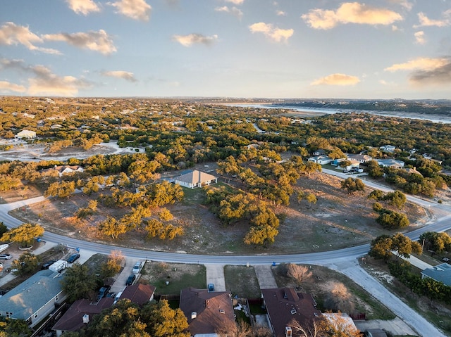 aerial view at dusk featuring a water view