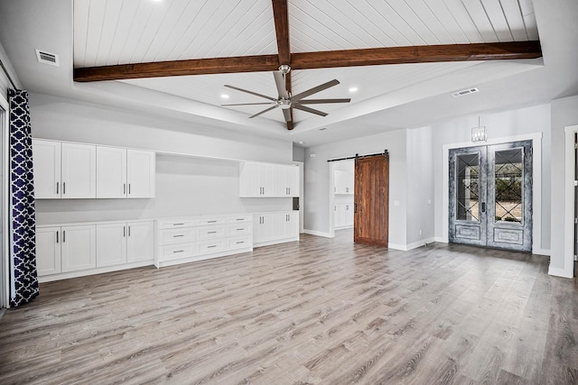 unfurnished living room with wood ceiling, a barn door, light hardwood / wood-style floors, beamed ceiling, and ceiling fan