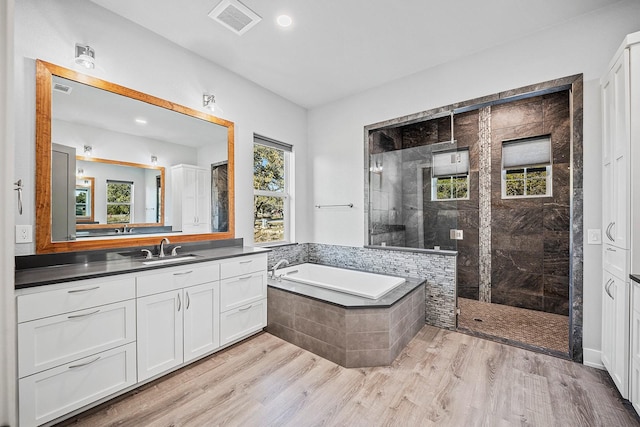 bathroom with vanity, hardwood / wood-style flooring, and separate shower and tub