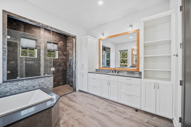 bathroom featuring vanity, separate shower and tub, and hardwood / wood-style floors