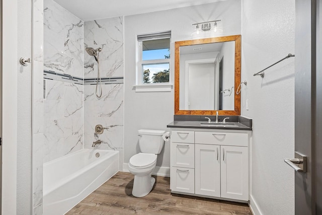 full bathroom featuring toilet, tiled shower / bath combo, vanity, and hardwood / wood-style floors