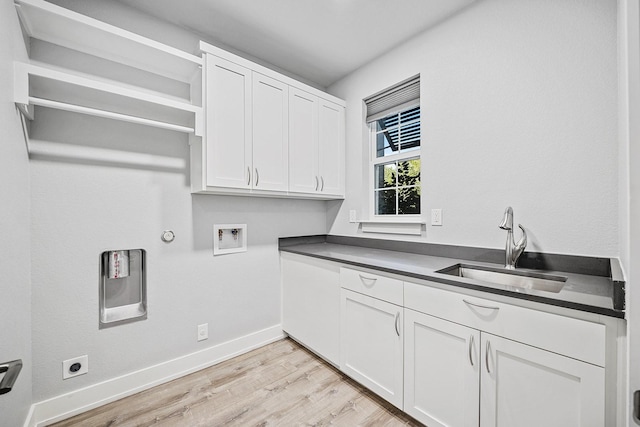 laundry area featuring sink, washer hookup, cabinets, light hardwood / wood-style flooring, and hookup for a gas dryer