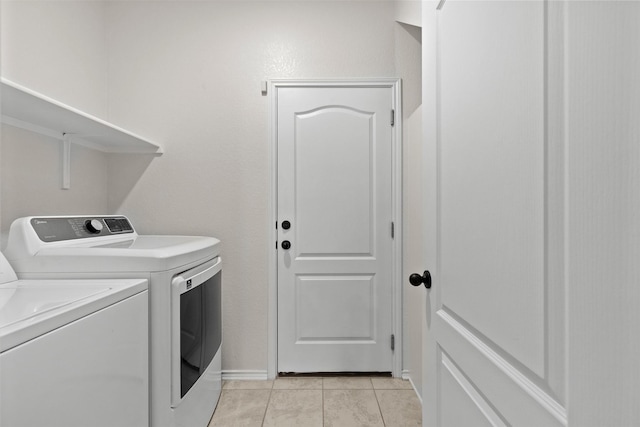 laundry area with washing machine and dryer and light tile patterned flooring