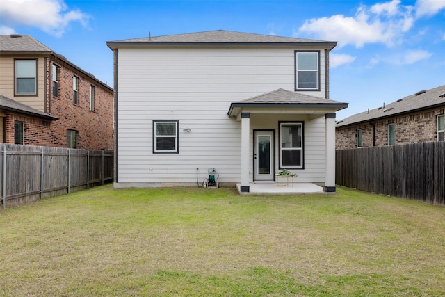 rear view of house featuring a yard and a patio