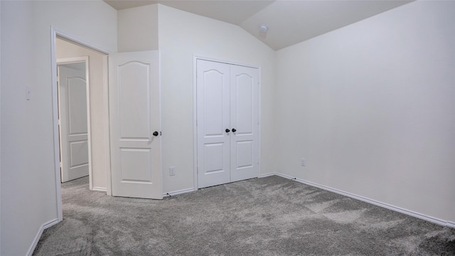 unfurnished bedroom with a closet, carpet, and lofted ceiling