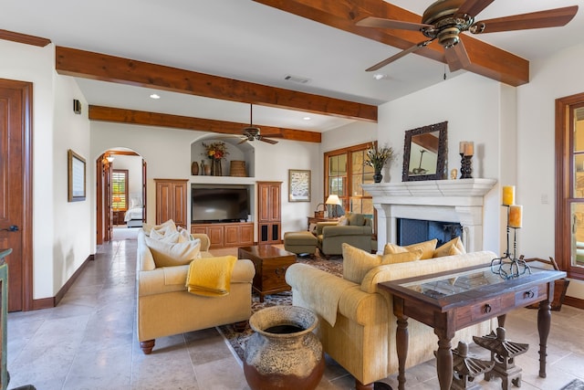 living room featuring ceiling fan and beam ceiling