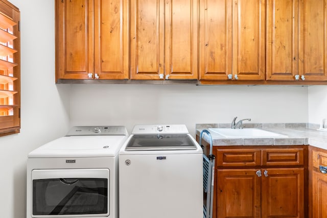 laundry area with sink, cabinets, and independent washer and dryer