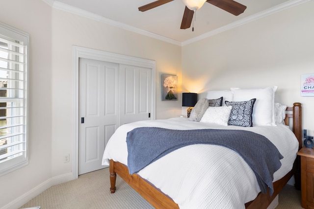 bedroom featuring ceiling fan, a closet, crown molding, and light carpet