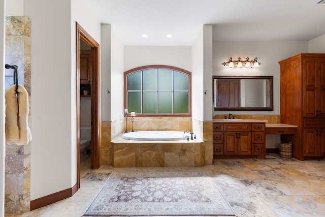 bathroom featuring toilet, tiled tub, and vanity