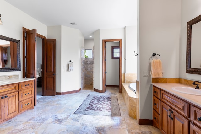 bathroom featuring vanity and a relaxing tiled tub