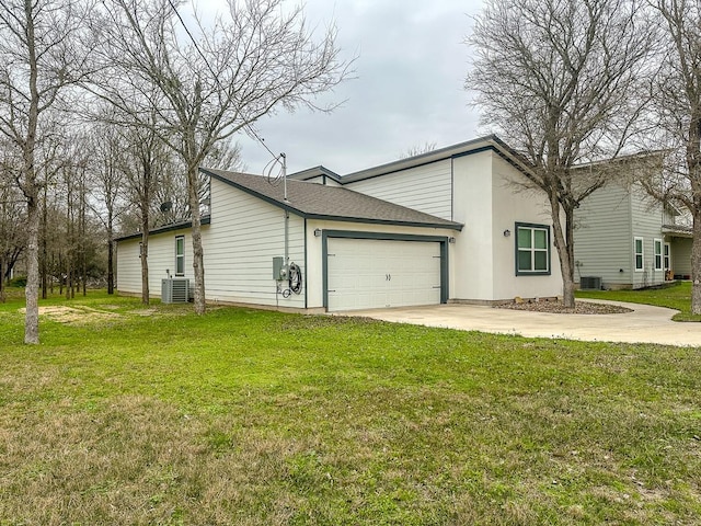 exterior space with a lawn, central AC unit, and a garage